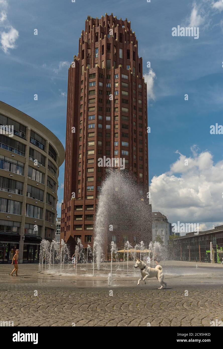 Les enfants jouent dans les eaux qui s'écoulent de la fontaine en face de la tour de la place principale, Francfort, Allemagne Banque D'Images