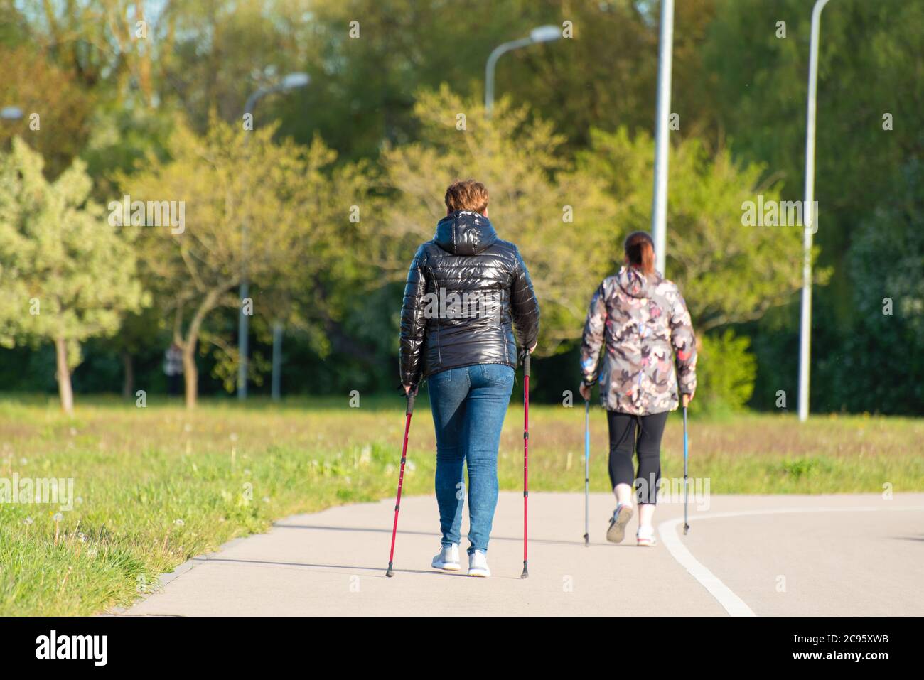 des femmes de plus grande taille avec des bâtons de marche nordique à la formation de parc de la ville pour maintenir la santé et combattre le surpoids Banque D'Images