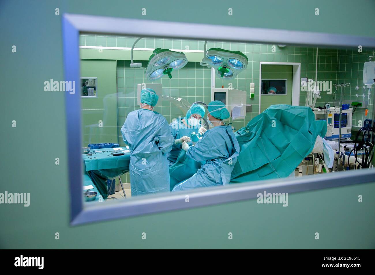 Essen, Rhénanie-du-Nord-Westphalie, Allemagne - Hôpital. Vue dans une salle d'opération à travers une fenêtre. Une équipe chirurgicale travaille sur une opération au pied. - Banque D'Images