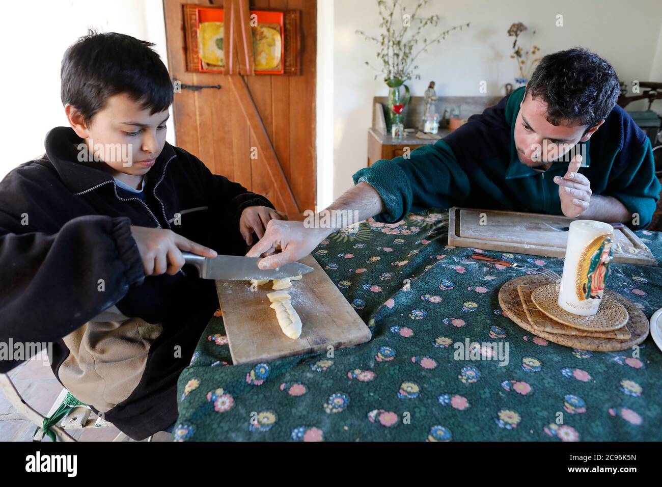 Jeune homme montrant à son frère cadet comment faire du gnochi à Eure, France. Banque D'Images