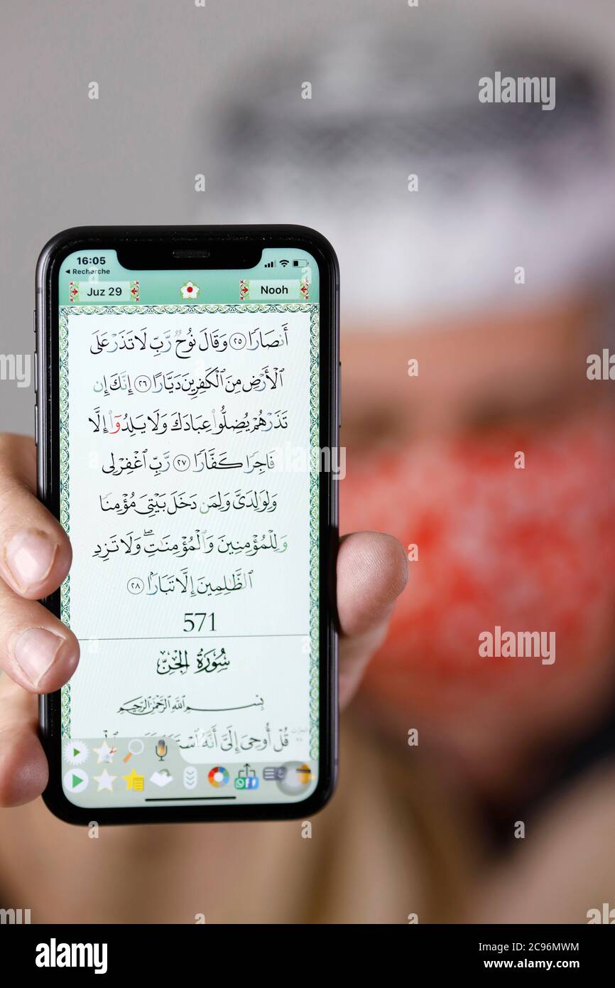 Homme montrant un Coran électronique sur un smartphone. France. Banque D'Images