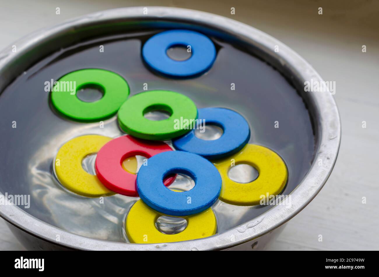 Détails multicolores de l'ensemble de créateur pour enfants dans un bol en métal avec eau. Nettoyer les jouets des enfants de la poussière et de la saleté. Hygiène, soins de santé. Sélection Banque D'Images