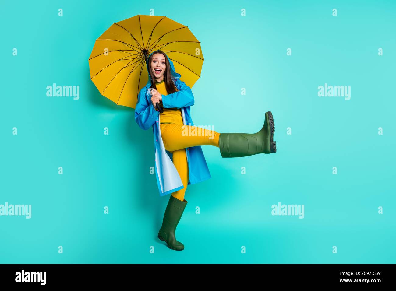 Photo du corps entier d'une belle dame gaie humeur temps pluvieux marche  capuche tête puddles lever la jambe tenir grand parapluie usure veste de  pluie pantalon de chandail gomme Photo Stock -