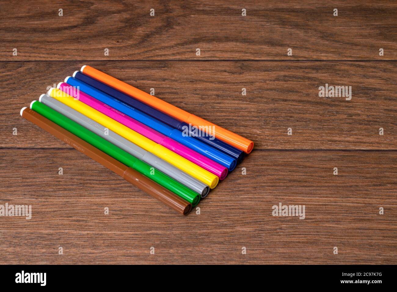 Beaucoup de stylos-feutres multicolores colorés et vibrants sur un fond en bois marron. Banque D'Images