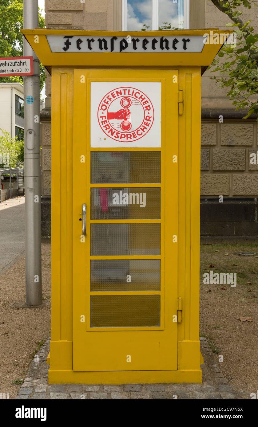 Un ancien téléphone jaune stand dans la ville de Frankfurtm Allemagne Banque D'Images