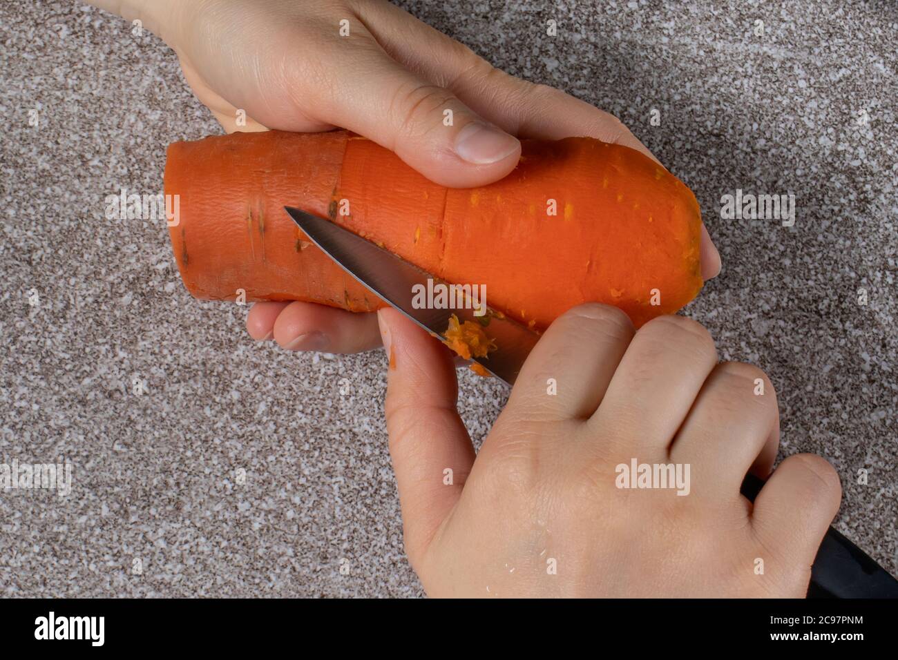 Éplucher les carottes cuites. Le processus de préparation des aliments. Banque D'Images