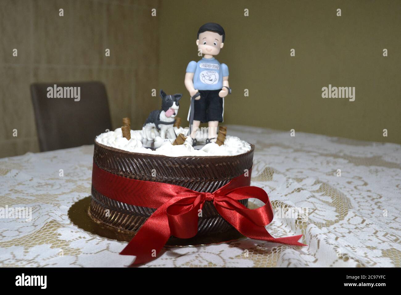 Gateau D Anniversaire Avec Ruban Rouge Et Une Figure D Enfant Avec Son Chien Sur Une Nappe Blanche Et Un Fond Flou Bresil Amerique Du Sud Photo Stock Alamy