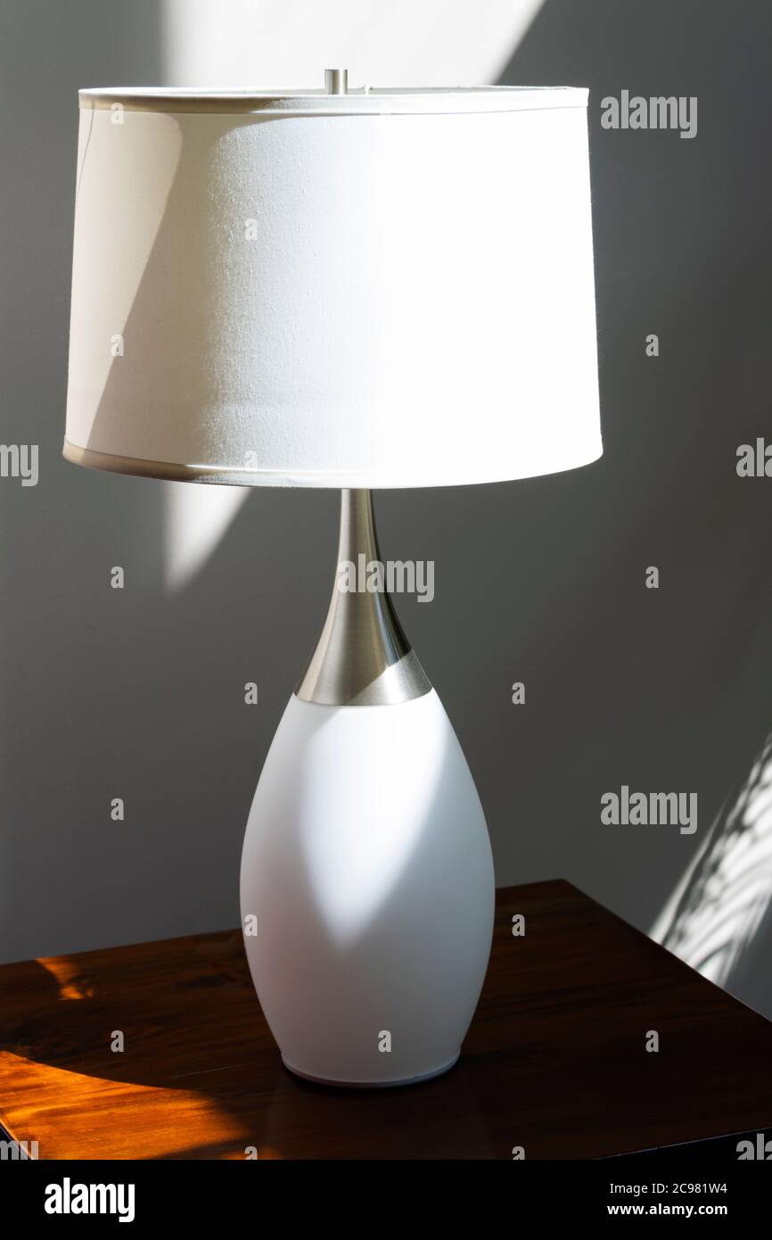 Lampe sur table éclairée à la lumière naturelle solaire le matin dans la salle. Banque D'Images