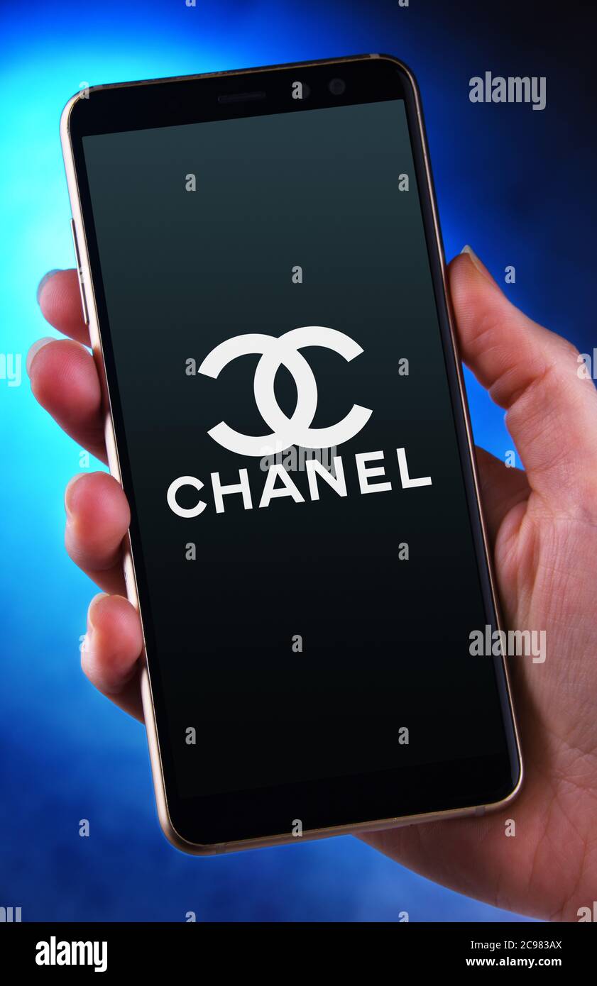 POZNAN, POL - 12 JUIN 2020: Main tenant smartphone affichant le logo de Chanel, une société de luxe qui se concentre sur la haute mode et prêt-à-porter des vêtements, l Banque D'Images