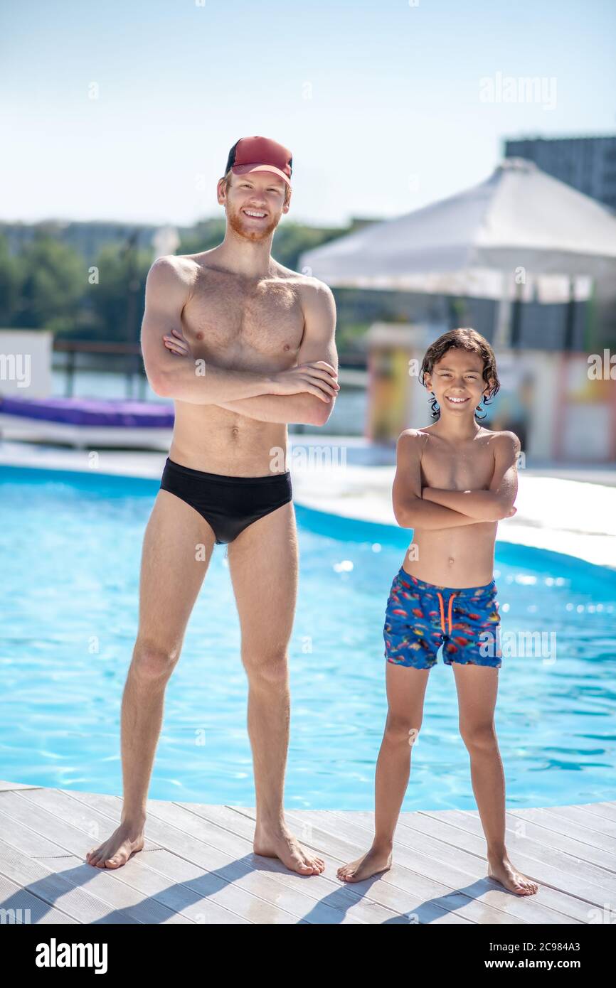 Homme et garçon en maillot de bain près de la piscine Photo Stock - Alamy