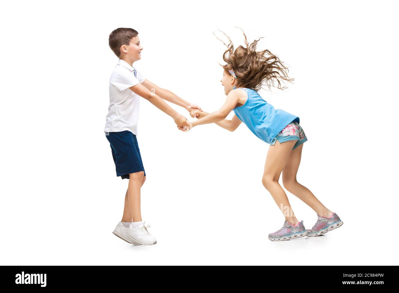 Des enfants heureux, un petit garçon et une fille caucasien émotif sautant et courant isolés sur fond blanc. Soyez heureux, gai, sincère. CopySpace pour publicité. Enfance, éducation, concept de bonheur. Banque D'Images