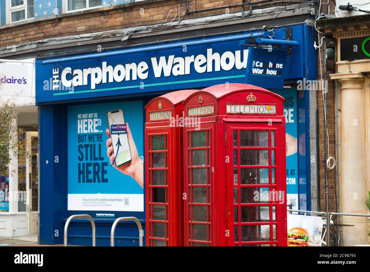 Les anciennes boîtes téléphoniques rouges originales sont gérées par BT devant un magasin d'entrepôt de téléphonie automobile qui vient d'être fermé en raison de l'évolution de l'industrie des communications téléphoniques. Bournemouth Angleterre Royaume-Uni (120) Banque D'Images