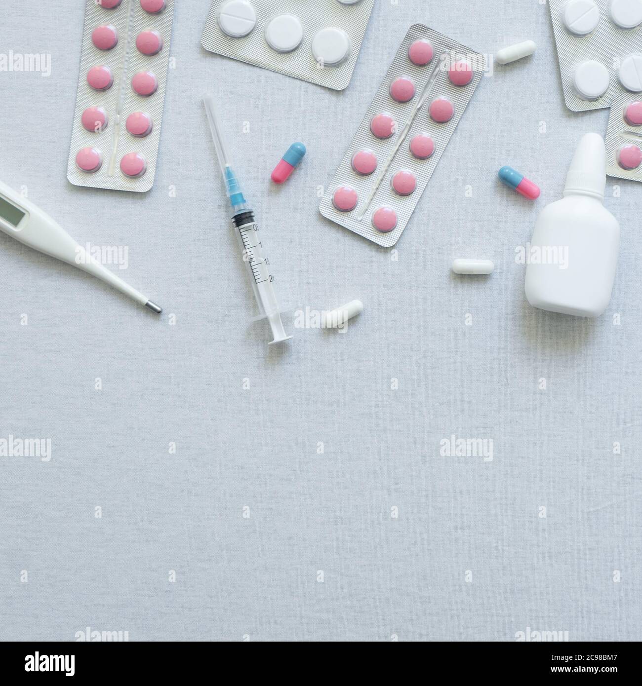 vue de dessus du thermomètre, des pilules et du vaporisateur nasal sur fond blanc Banque D'Images