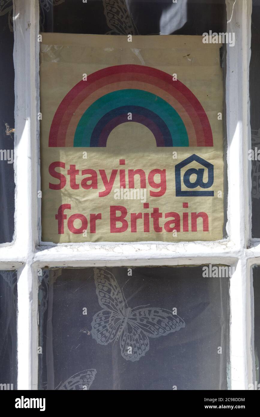 Rester à la maison pour la Grande-Bretagne, arc-en-ciel dans une fenêtre de maison Banque D'Images