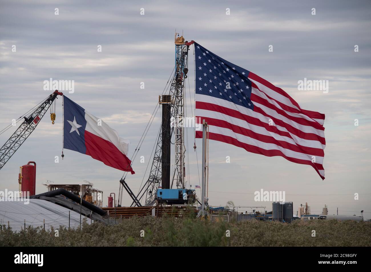 Midland, Texas, États-Unis. 29 juillet 2020. Les drapeaux du Texas et des États-Unis ornent un site de forage au sud-est de Midland, au Texas, où le président américain Donald Trump (non présenté) se rendra le 29 juillet 2020 à la suite d'une collecte de fonds et d'une table ronde à Odessa, une ville voisine. Trump devrait signer des proclamations préconisant une dépendance accrue à la production de pétrole du bassin Permien crédit : Bob Daemmrich/ZUMA Wire/Alamy Live News Banque D'Images