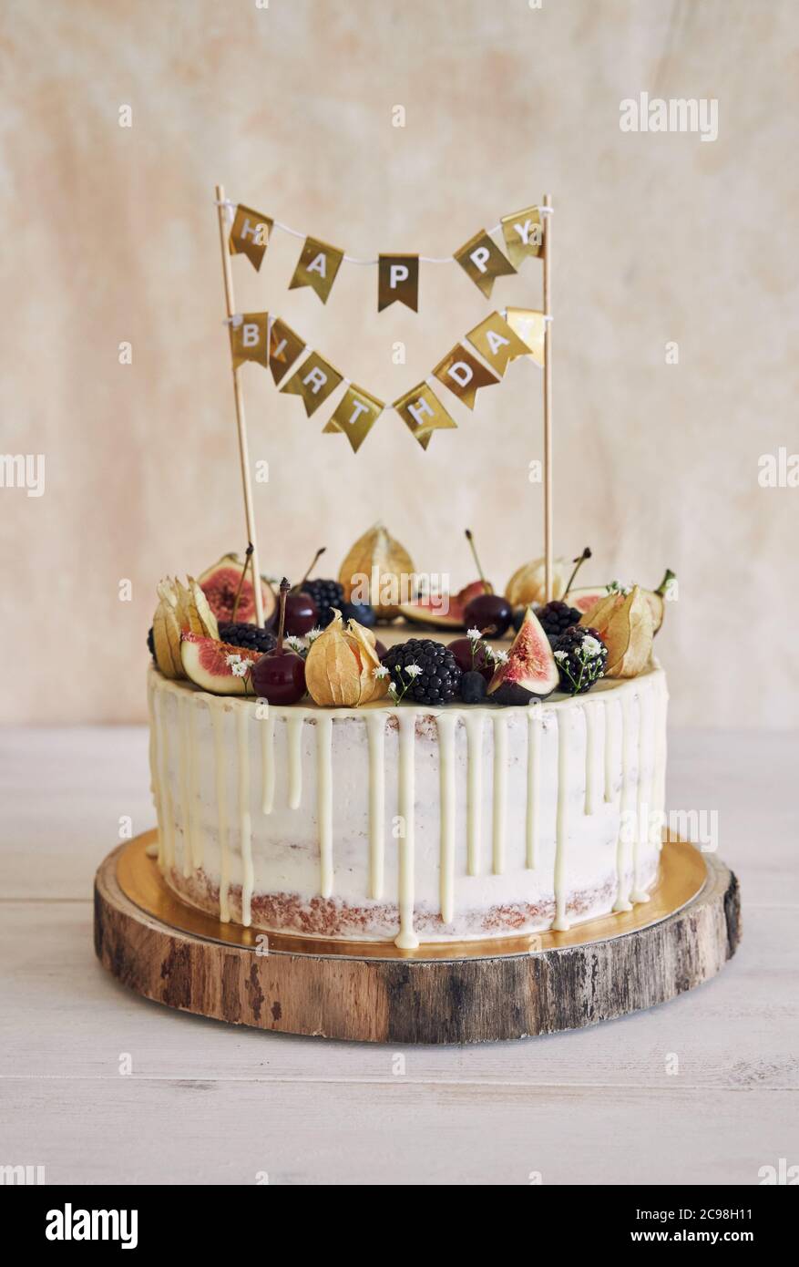 Un Gateau D Anniversaire Fruite Avec Un Surmontoir D Anniversaire Des Fruits Sur Le Dessus Et Une Goutte Blanche Sur Fond Beige Photo Stock Alamy