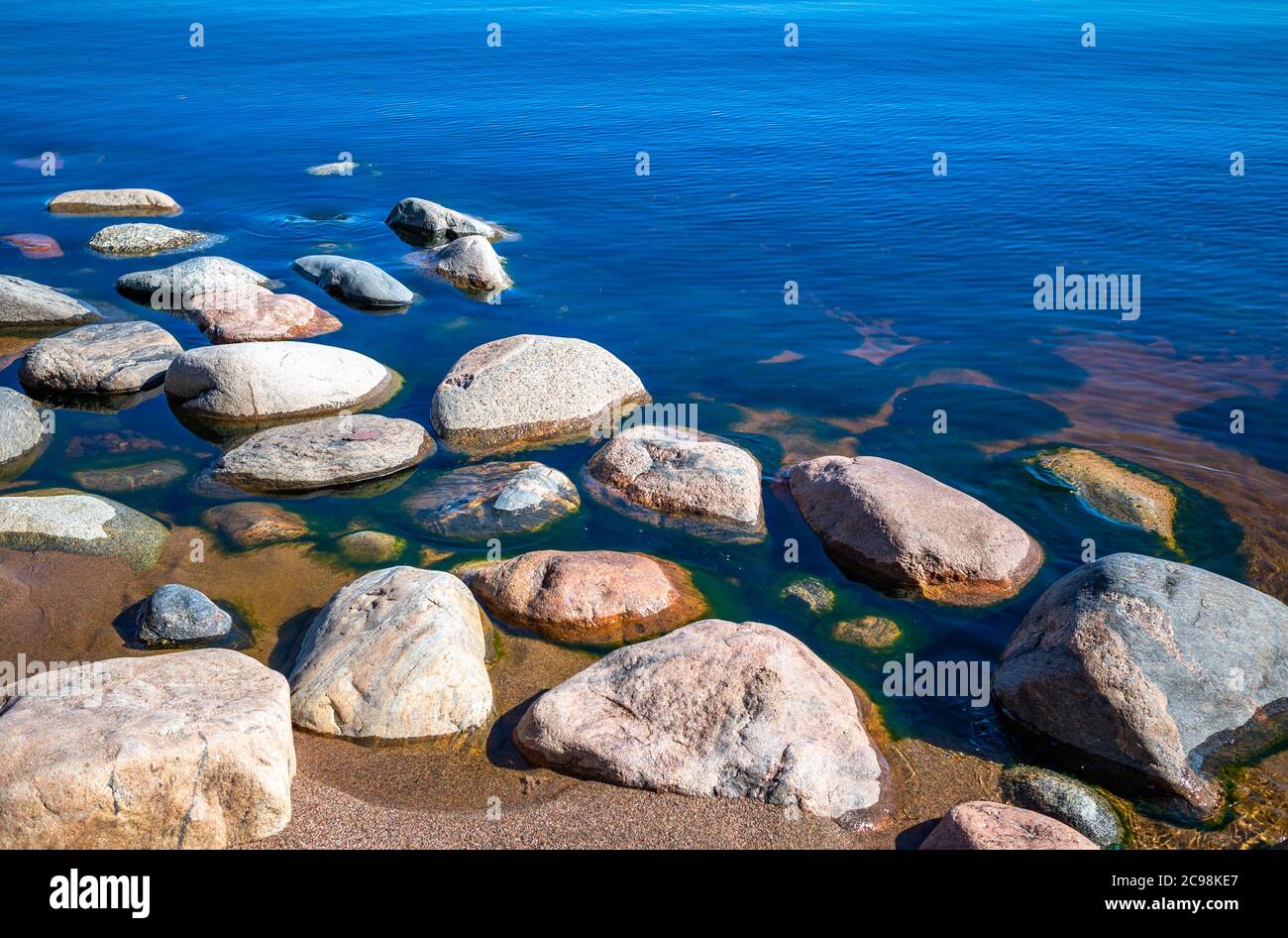 Pierres dans l'eau claire bleue du lac. Lac Ladoga, Russie. Banque D'Images