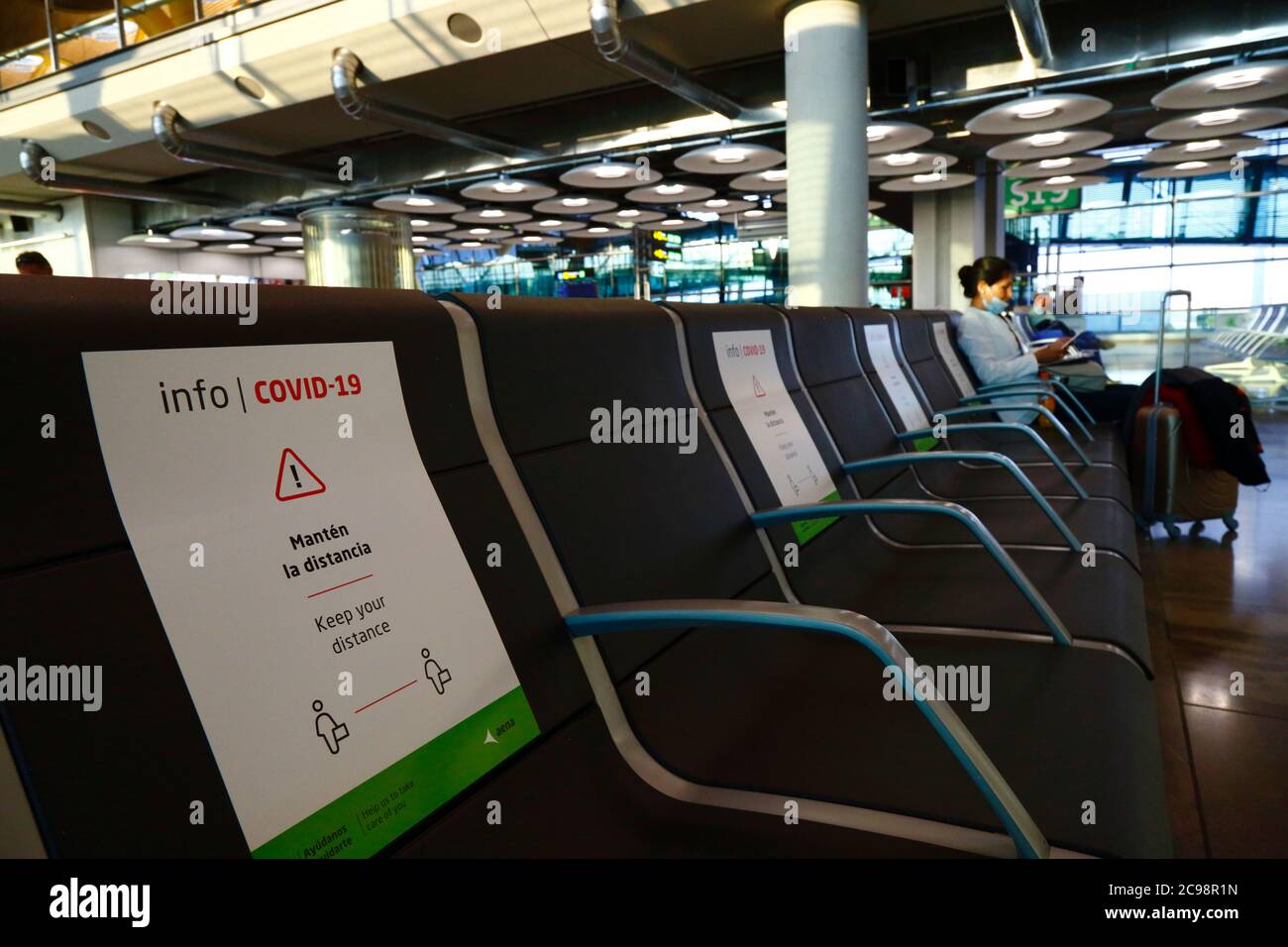 28 juillet 2020, aéroport de Barajas, Madrid, Espagne : panneaux sur les sièges pour aider les passagers à se conformer à la distance sociale dans le salon de départ presque vide du bâtiment terminal 4S de l'aéroport de Barajas. Un nombre réduit de vols est actuellement en service entre les pays européens après le verrouillage pour contrôler le coronavirus Covid-19, et les gouvernements ont mis en place un système de ponts aériens pour faciliter les voyages et le tourisme. L'Espagne a connu un certain nombre de nouvelles épidémies ces derniers jours, ce qui a incité le gouvernement britannique à annoncer que les personnes qui rentrent au Royaume-Uni depuis l'Espagne devraient mettre en quarantaine pendant 14 jours à leur arrivée. Banque D'Images