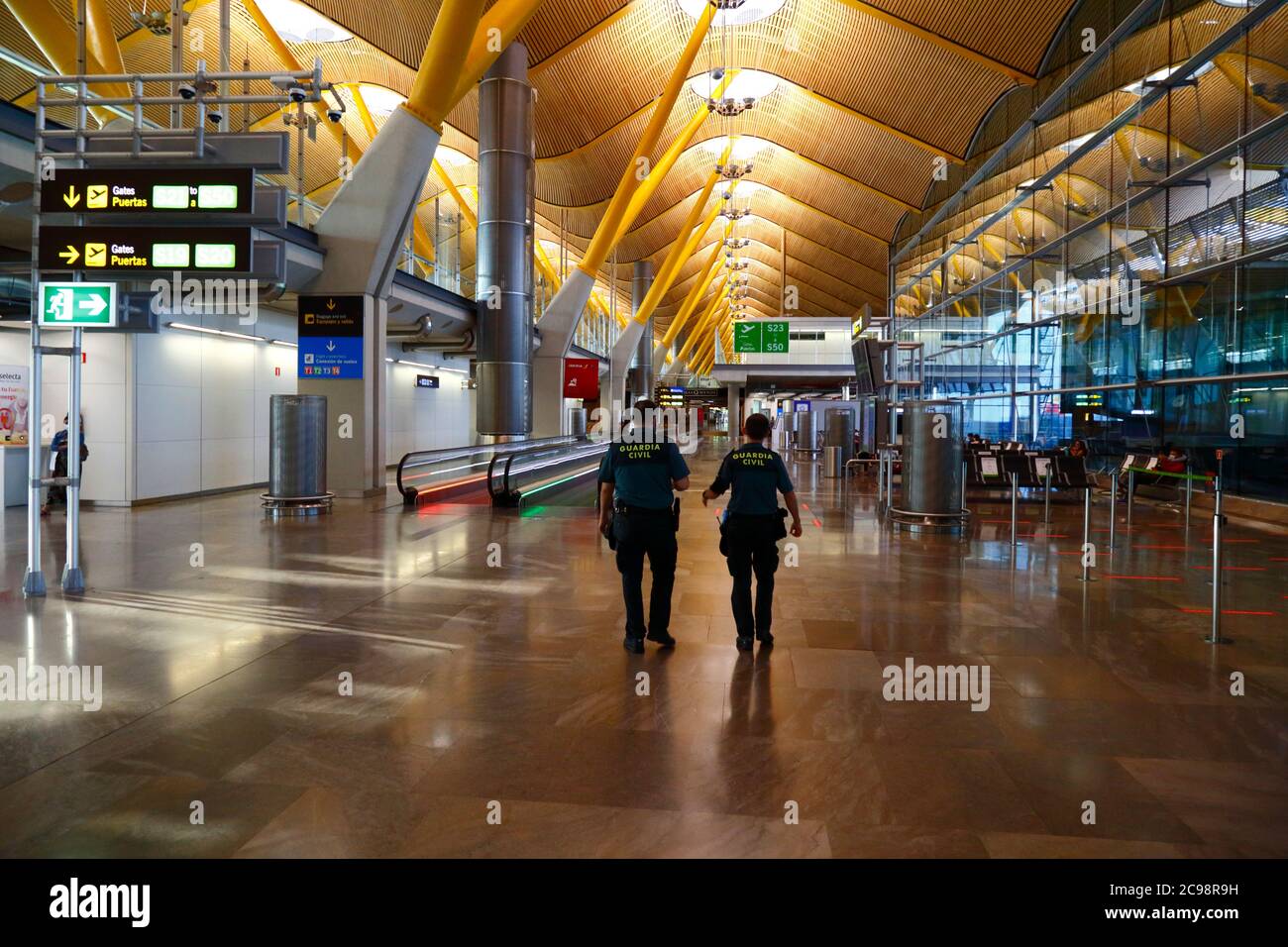 28 juillet 2020, aéroport de Barajas, Madrid, Espagne: Les gardes civils / Guardia des officiers civils passent par le coin salon des portes de départ vides du terminal 4S de l'aéroport de Barajas. Un nombre réduit de vols est actuellement en service entre les pays européens après le verrouillage pour contrôler le coronavirus Covid-19, et les gouvernements ont mis en place un système de ponts aériens pour faciliter les voyages et le tourisme. L'Espagne a connu un certain nombre de nouvelles flambées ces derniers jours, ce qui a incité le gouvernement britannique à annoncer que les personnes qui rentrent au Royaume-Uni depuis l'Espagne devraient mettre en quarantaine pendant 14 jours à leur arrivée. Banque D'Images 28 juillet 2020, aéroport de Barajas, Madrid, Espagne: Les gardes civils / Guardia des officiers civils passent par le coin salon des portes de départ vides du terminal 4S de l'aéroport de Barajas. Un nombre réduit de vols est actuellement en service entre les pays européens après le verrouillage pour contrôler le coronavirus Covid-19, et les gouvernements ont mis en place un système de ponts aériens pour faciliter les voyages et le tourisme. L'Espagne a connu un certain nombre de nouvelles flambées ces derniers jours, ce qui a incité le gouvernement britannique à annoncer que les personnes qui rentrent au Royaume-Uni depuis l'Espagne devraient mettre en quarantaine pendant 14 jours à leur arrivée. Banque D'Images