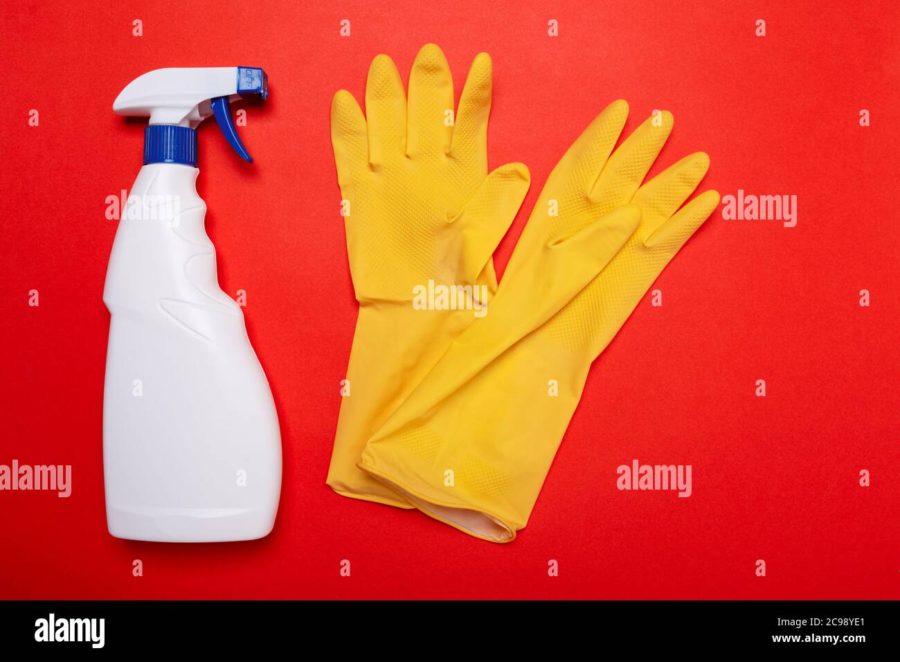 essuie-glace blanc et gants jaunes sur fond rouge. CopySpace. Banque D'Images