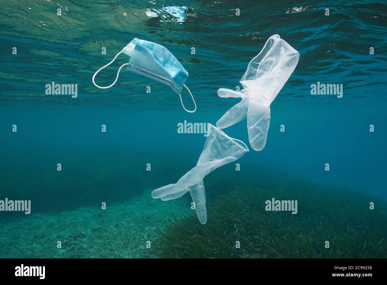 Gants jetables et masque facial sous l'eau, pollution des déchets plastiques dans la mer depuis la pandémie du coronavirus COVID-19 Banque D'Images