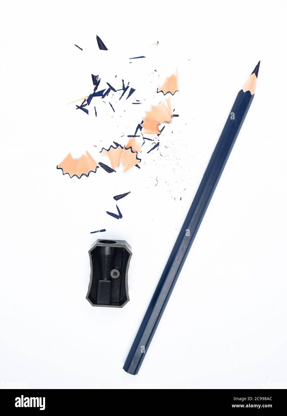 Peu de matériaux d'étude contenant un crayon bleu et un taille-crayon en plastique noir isolé Banque D'Images