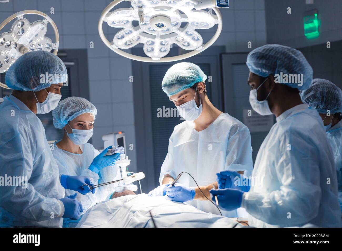 La chirurgie d'urgence. Chirurgiens intelligents smart professionnel debout près du patient et l'exécution d'une opération lors de l'enregistrement de sa vie. Trea professionnel Banque D'Images