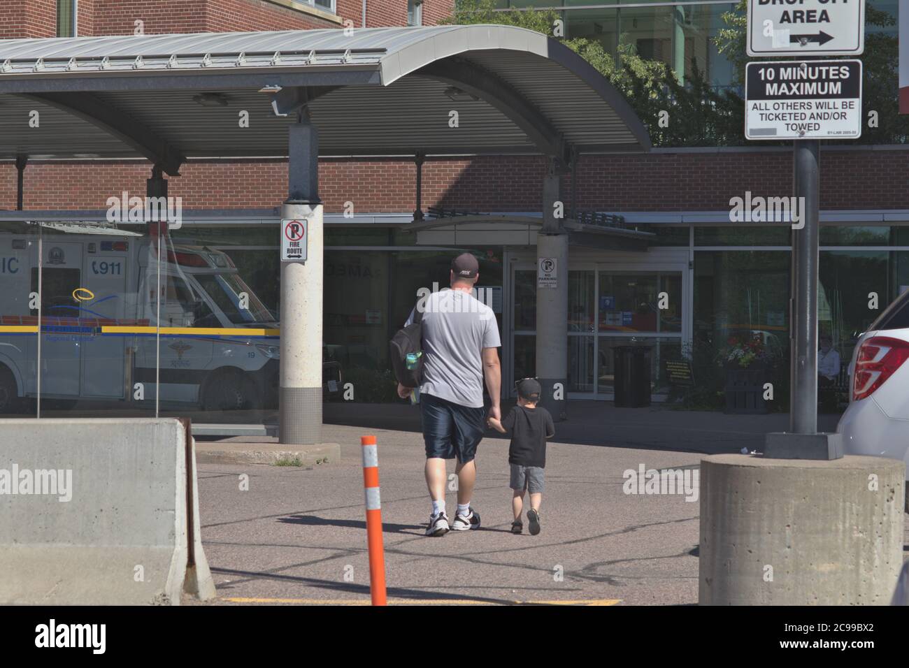 homme et enfant marchant aux urgences à l'hôpital Banque D'Images