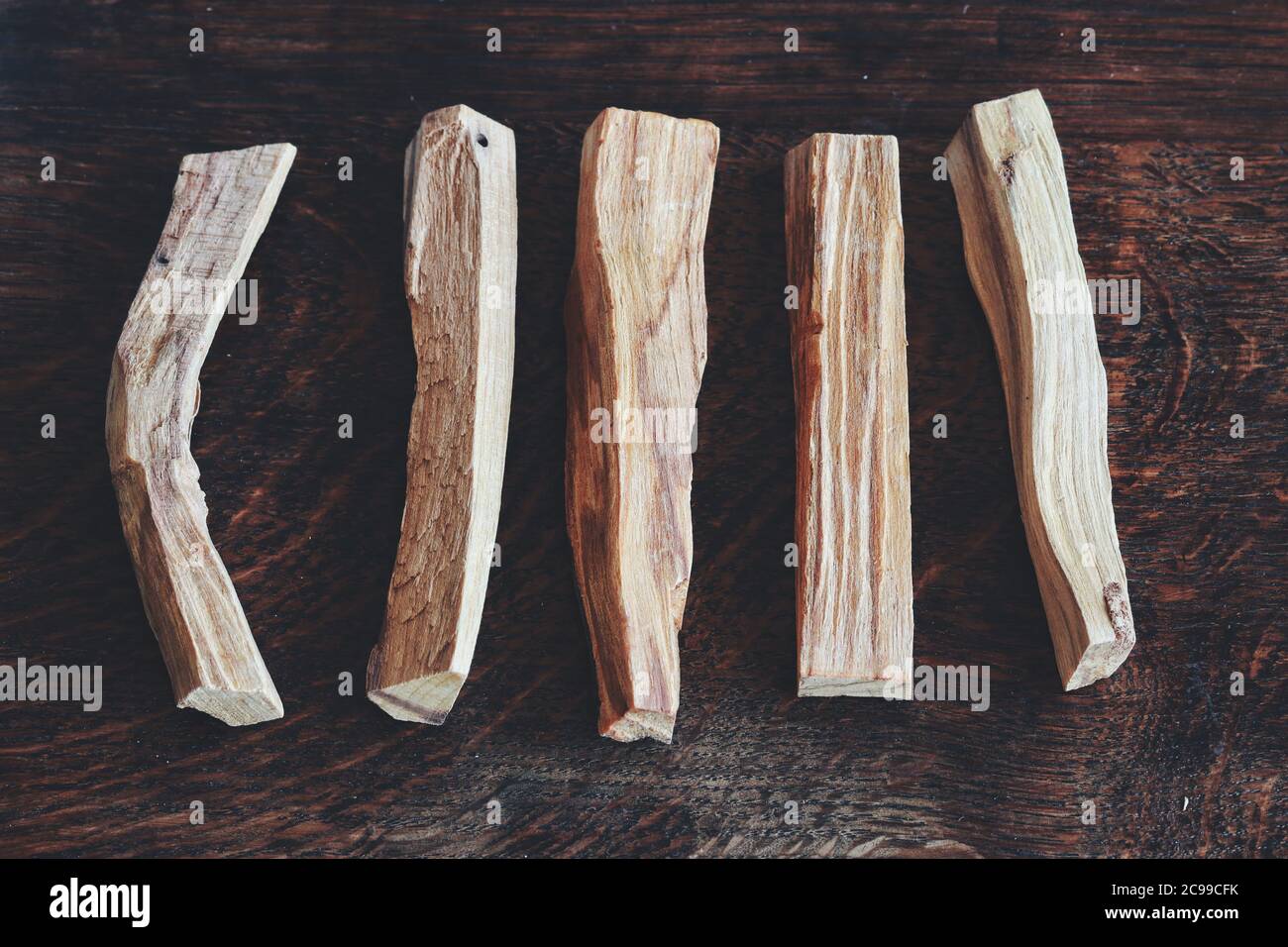 Pose plate de bâtonnets de Palo Santo de Bursera graveolens (bois Saint) sur une table en bois brun foncé. Écartez 5 cinq bras en une seule rangée Banque D'Images