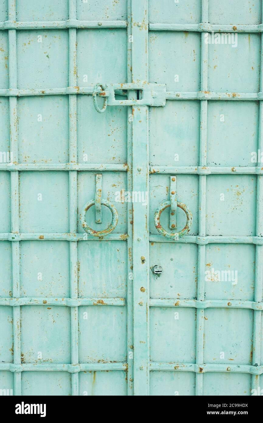 Les portes métalliques sont turquoise.avec des anneaux ronds poignées. Forgeage décoratif métallique. Banque D'Images