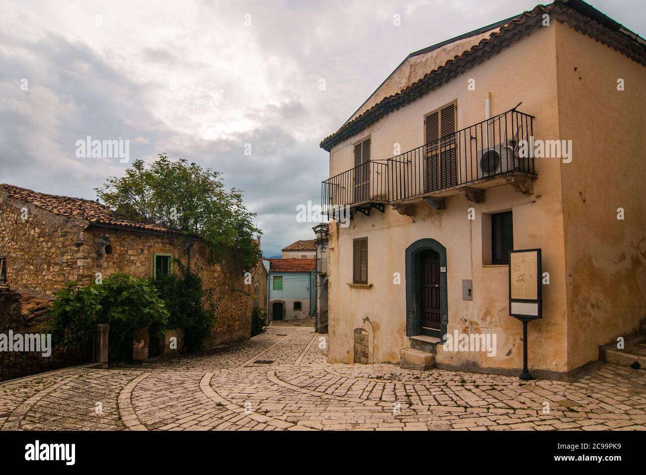 Une rue historique typique dans le village italien de Torella di Sannio à Molise avec des bâtiments en brique, un arbre et une maison ancienne Banque D'Images