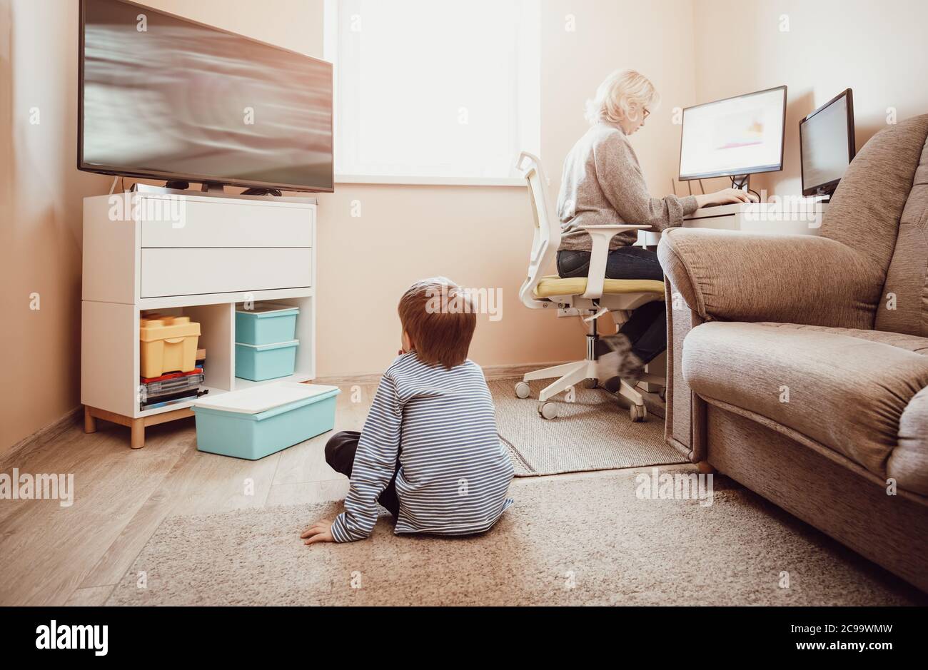 femme travaillant à la maison avec petit enfant. Banque D'Images