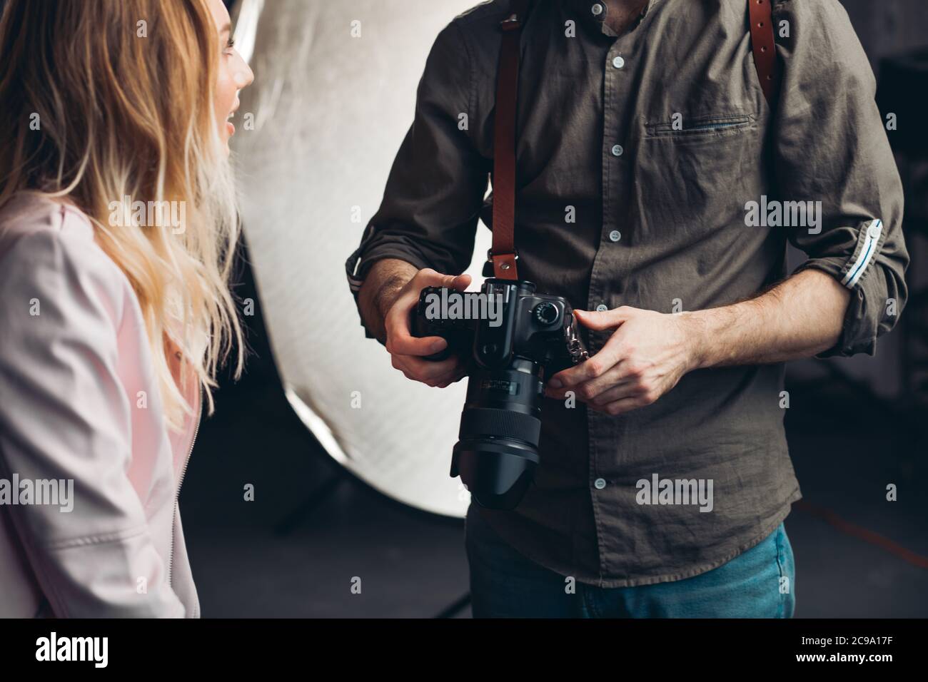 homme à la recherche de photos dans l'appareil tout en ayant une discussion avec une fille blonde , gros plan rogné photo Banque D'Images