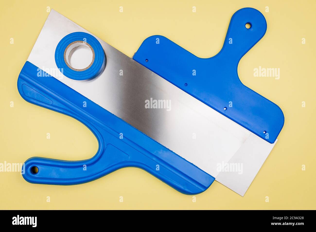 Spatule de différentes tailles et ruban électrique sur fond jaune. Banque D'Images