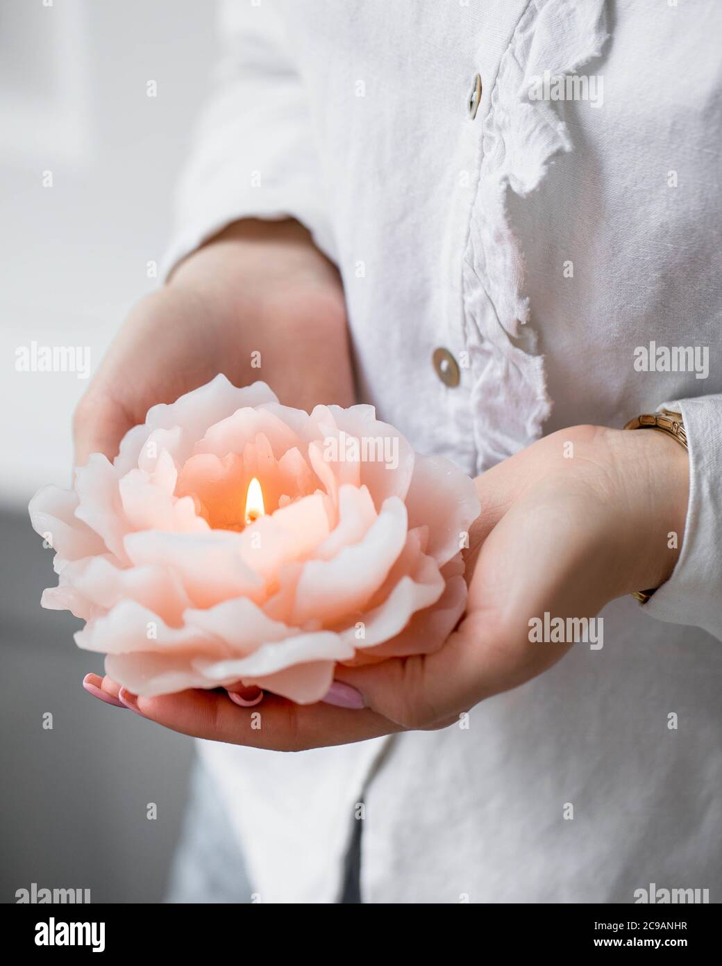 Photo verticale d'une femelle tenant une bougie en forme de rose un spa  sous les lumières Photo Stock - Alamy
