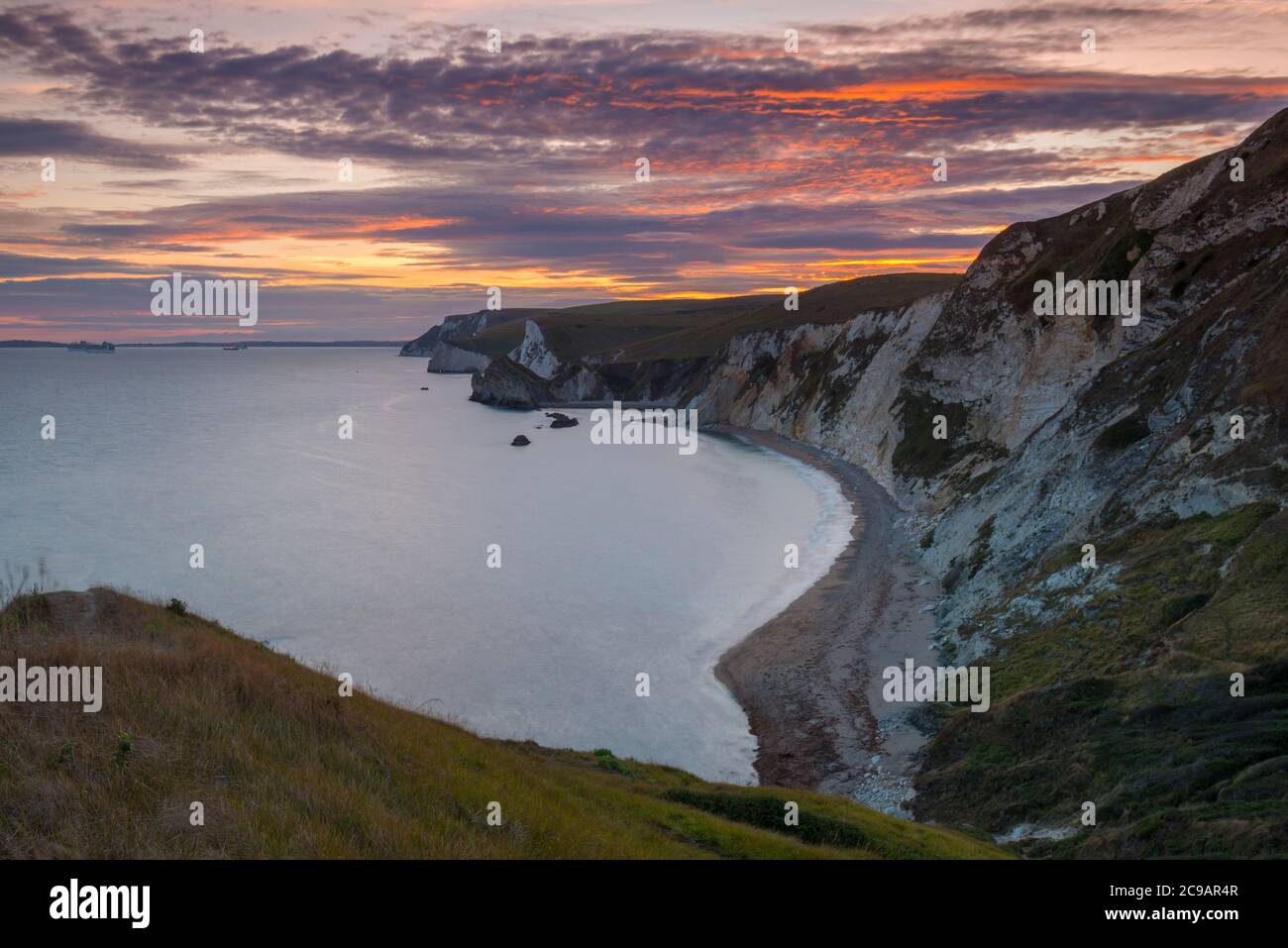 Dungy Head, West Lulworth, Dorset, Royaume-Uni. 29 juillet 2020. Météo Royaume-Uni. Au coucher du soleil, les nuages sont rayés et orange, depuis Dungy Head, à West Lulworth, dans Dorset, vers l'ouest, en direction de Man O'War Bay et Durdle Door. Crédit photo : Graham Hunt/Alamy Live News Banque D'Images