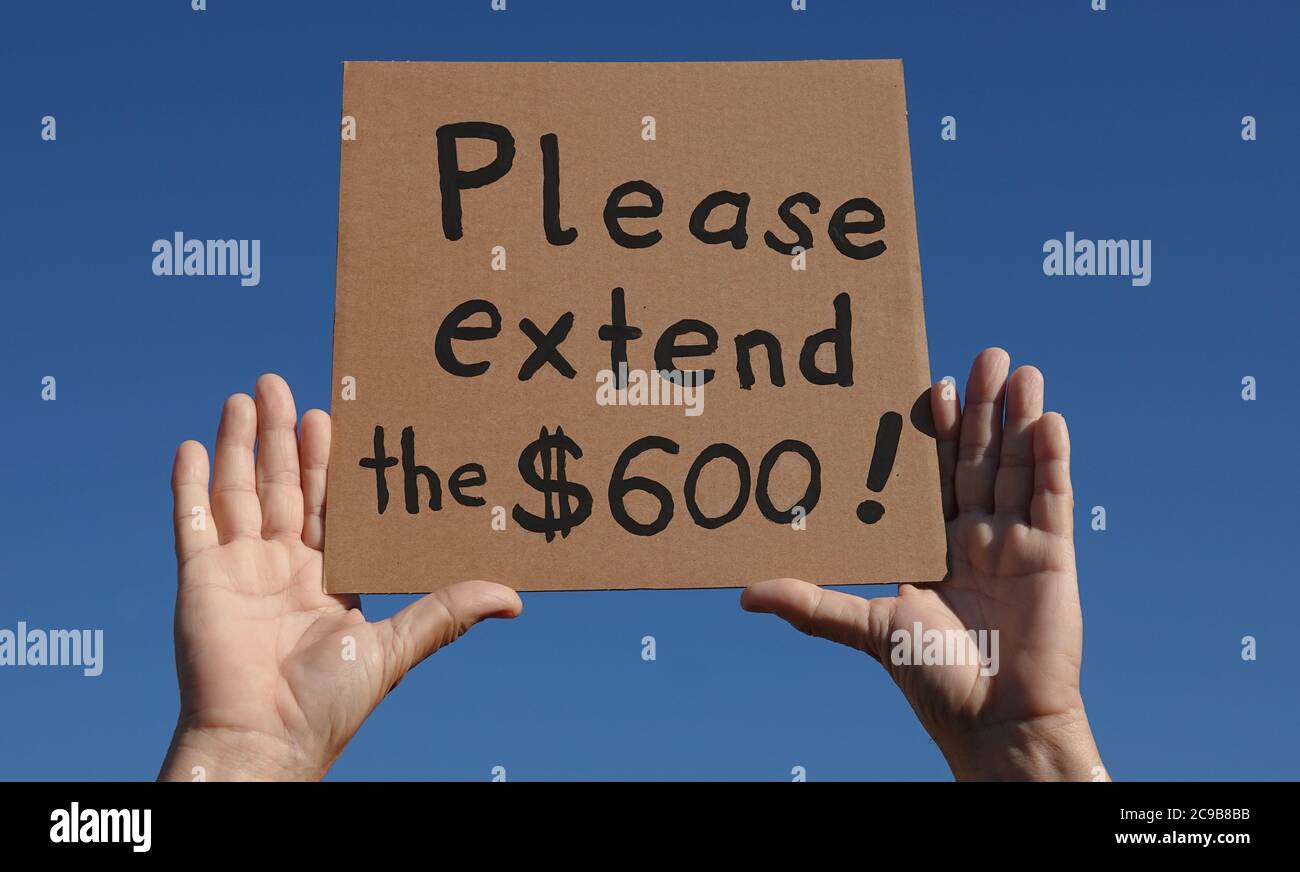 Les mains d'un homme portant un panneau en carton fait à la main qui plaide auprès du gouvernement américain pour maintenir les 600 dollars de prestations de chômage supplémentaires Banque D'Images