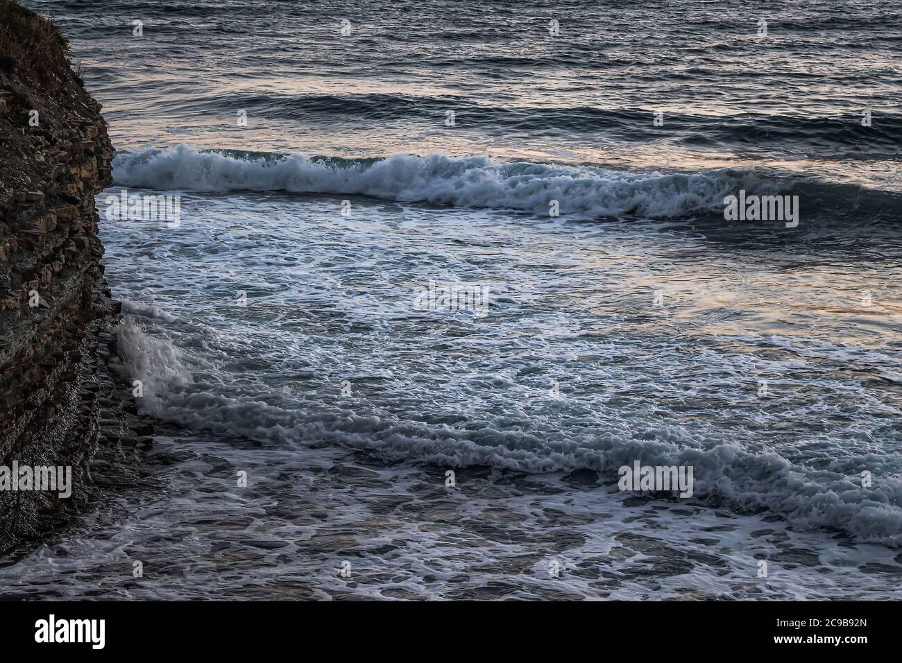 Des vagues d'un mètre de long se sont écrasées contre les rochers à grande vitesse. Vue rapprochée du paysage marin depuis le sommet de la falaise. La ville côtière de la mer Noire Banque D'Images