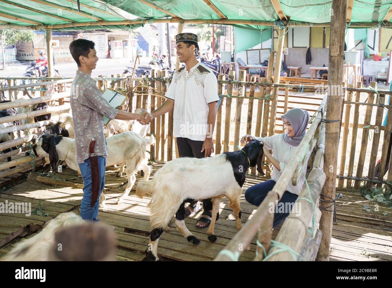 le peuple musulman se met à la main avec un fermier après avoir acheté une chèvre. idul adha sacrifice célébration Banque D'Images