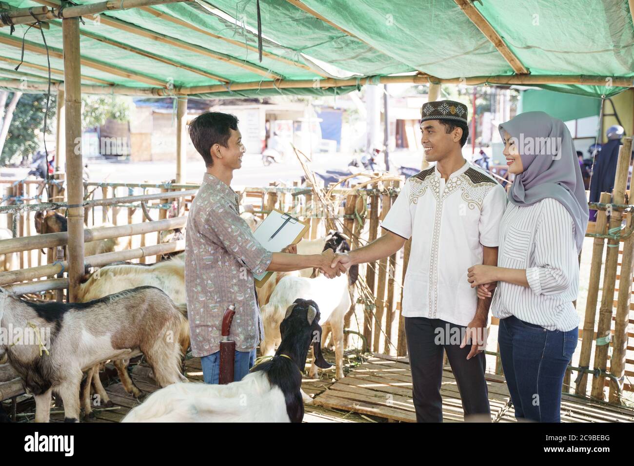 le peuple musulman se met à la main avec un fermier après avoir acheté une chèvre. idul adha sacrifice célébration Banque D'Images