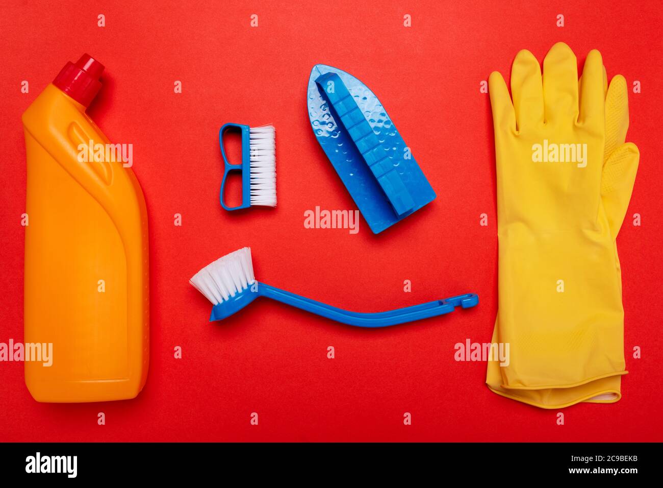 gants de toilette et brosses jaunes sur fond rouge. CopySpace Banque D'Images