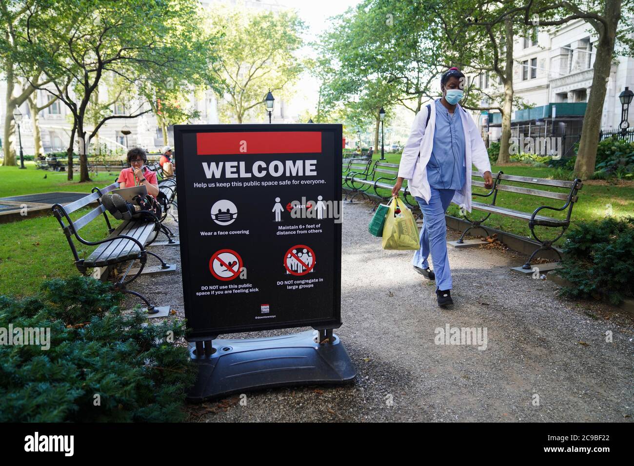 Washington, États-Unis. 29 juillet 2020. Une femme passe devant un avis de prévention de la propagation du COVID-19 à New York, aux États-Unis, le 29 juillet 2020. Crédit : Wang Ying/Xinhua/Alay Live News Banque D'Images