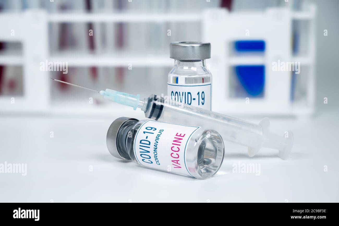 Concept médical. Seringue et ampoule de vaccin Covid-19 sur fond blanc. Banque D'Images
