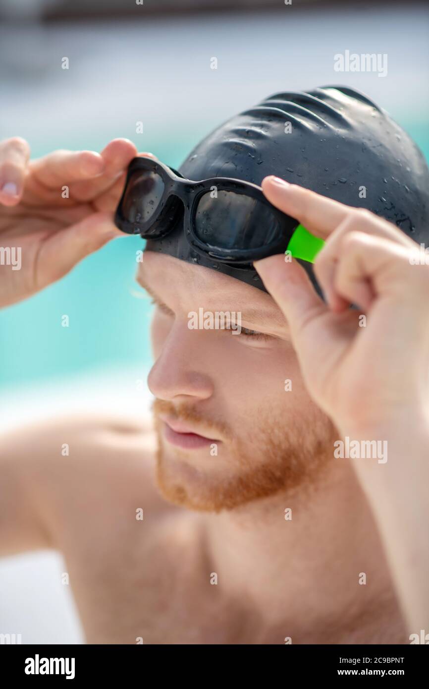 Gros plan sur le visage de l'homme dans la casquette et les lunettes de natation Banque D'Images