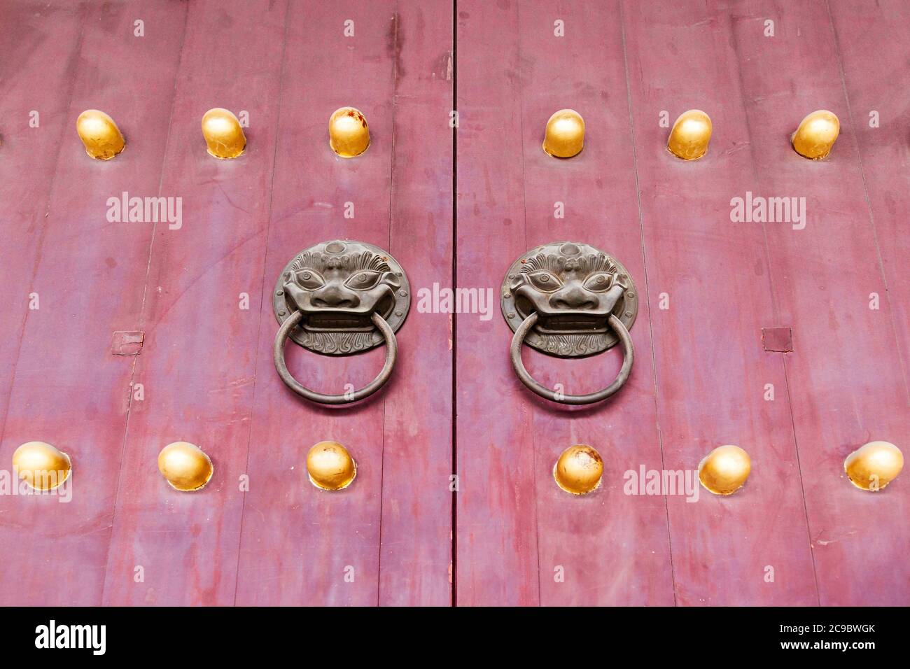 Porte en bois chinois rouge avec clous en métal et en or à Beijing, en Chine Banque D'Images