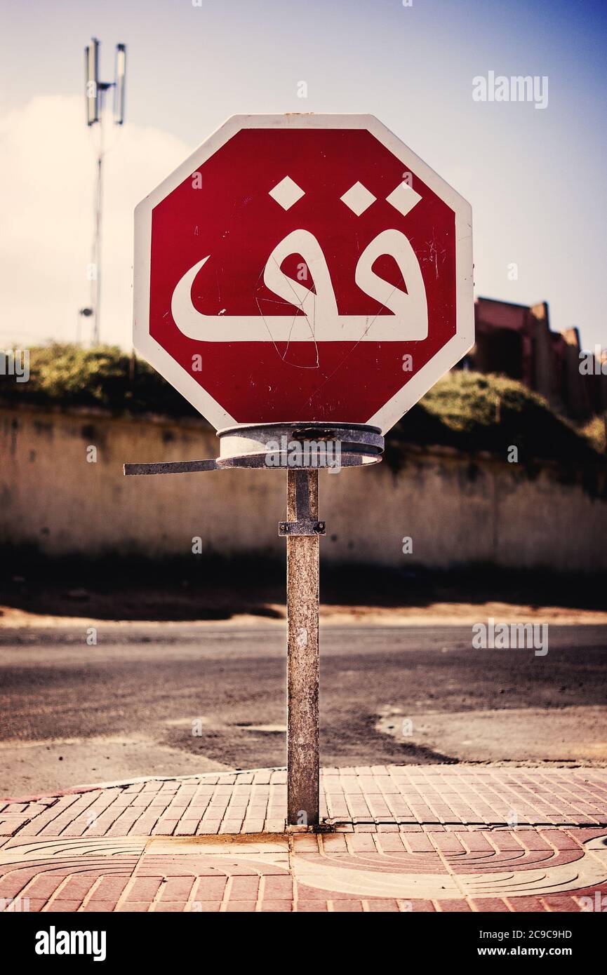 Signal de signalisation signalant un virage dangereux dans une route humide après la pluie au Maroc Banque D'Images