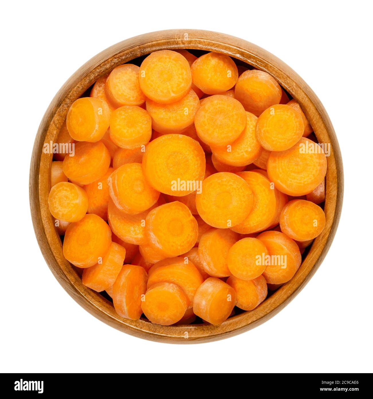 Petites tranches de carottes dans un bol en bois. Croquantes et fraîches, non pelées, petites et jeunes carottes, coupées en disques ronds, prêtes à manger et en-cas. Gros plan Banque D'Images