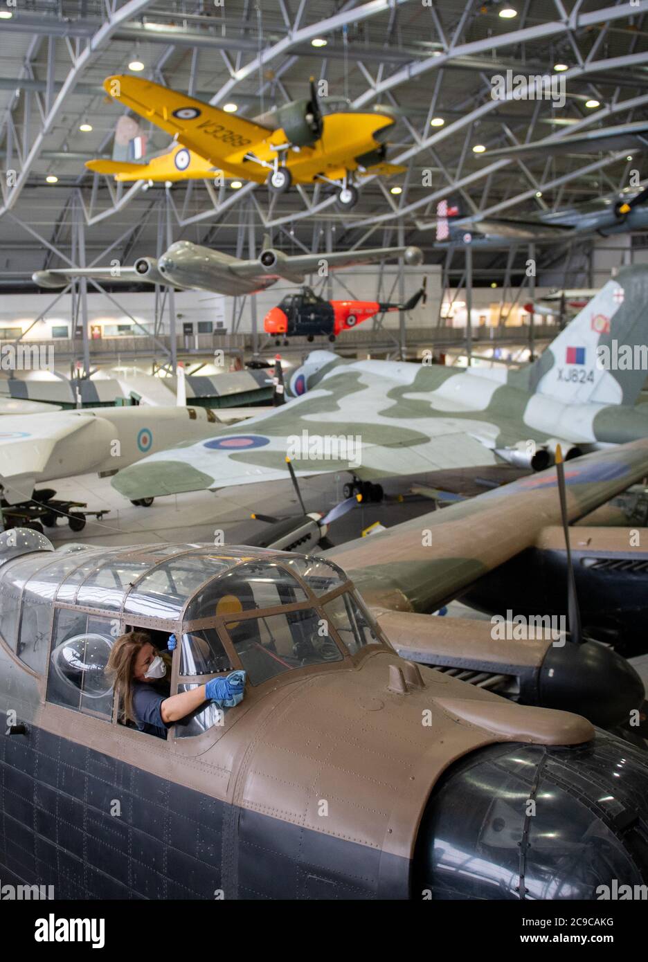 Samantha Archetti, conservateur préventif, nettoie le poste de pilotage d'un bombardier Avro Lancaster au Musée impérial de la guerre de Duxford alors que l'attraction se prépare à rouvrir au public samedi après l'assouplissement des restrictions de confinement en Angleterre. Banque D'Images