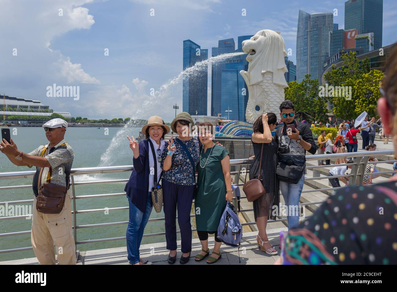 Photographié devant une statue du Merlion, symbole national de Singapour, créature mythique avec tête de lion et corps de poisson. Banque D'Images