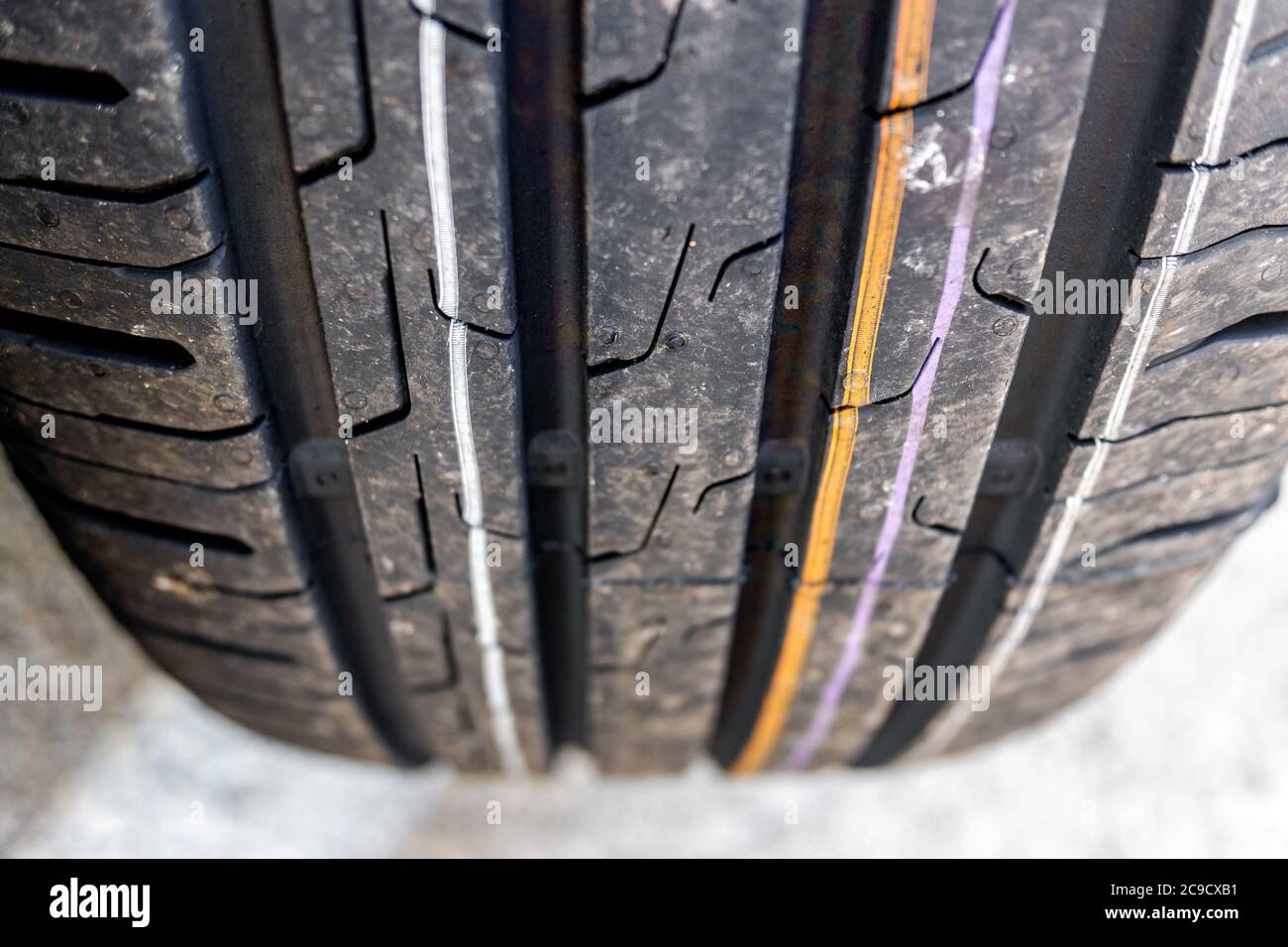 Accent mis sur le gros plan des pneus de voitures neuves avec marques de bande de roulement pour une bonne traction. Banque D'Images